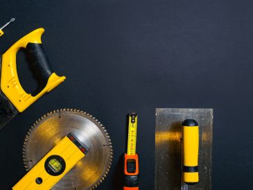 Hand tools arranged on a black surface, featuring saws, levels — See how Louisiana law views long-term occupation without a l