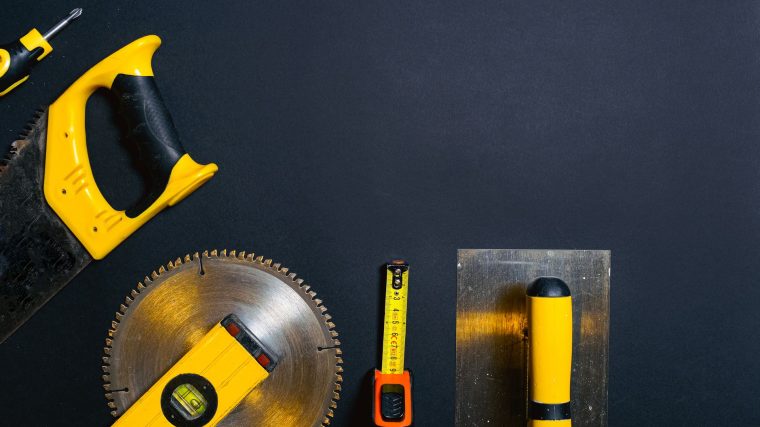 Hand tools arranged on a black surface, featuring saws, levels — See how Louisiana law views long-term occupation without a l